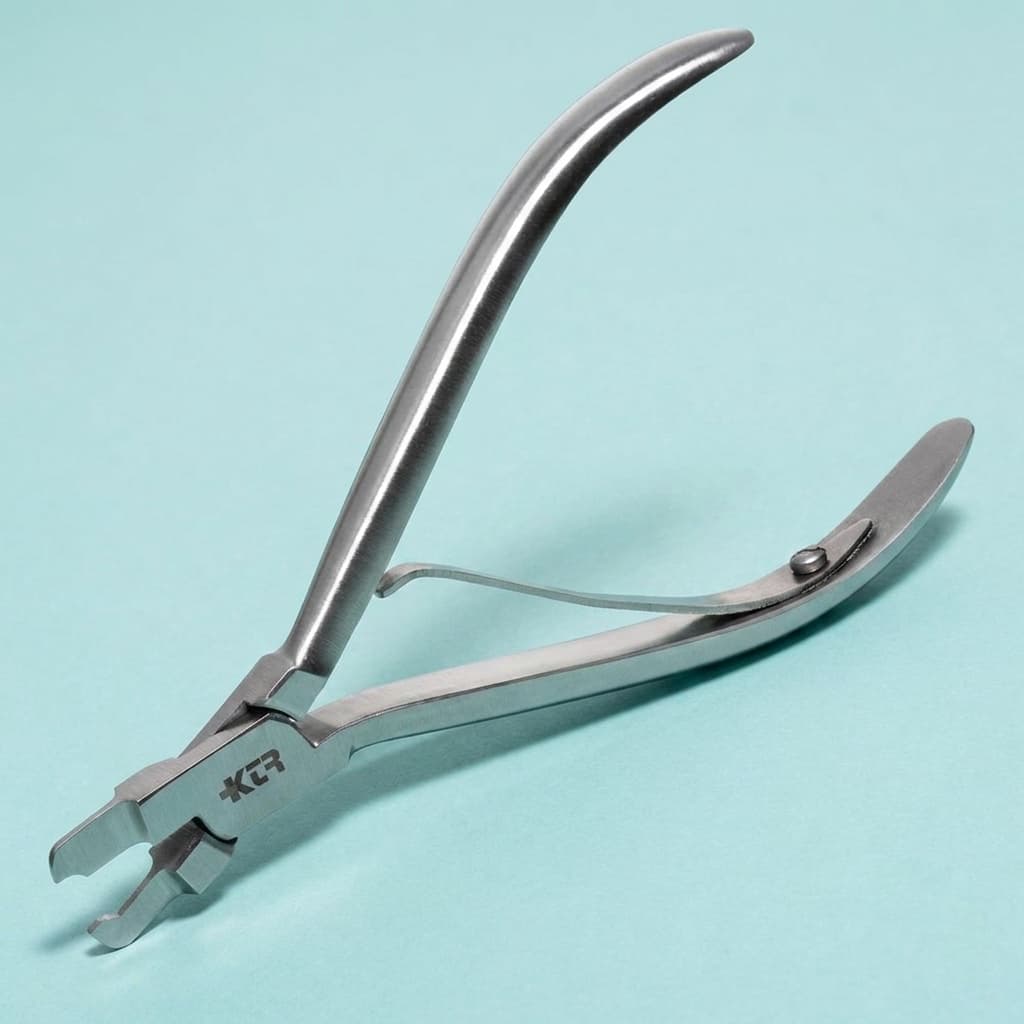 KTR crimping pliers for adapting stainless steel crown margins on a teal background