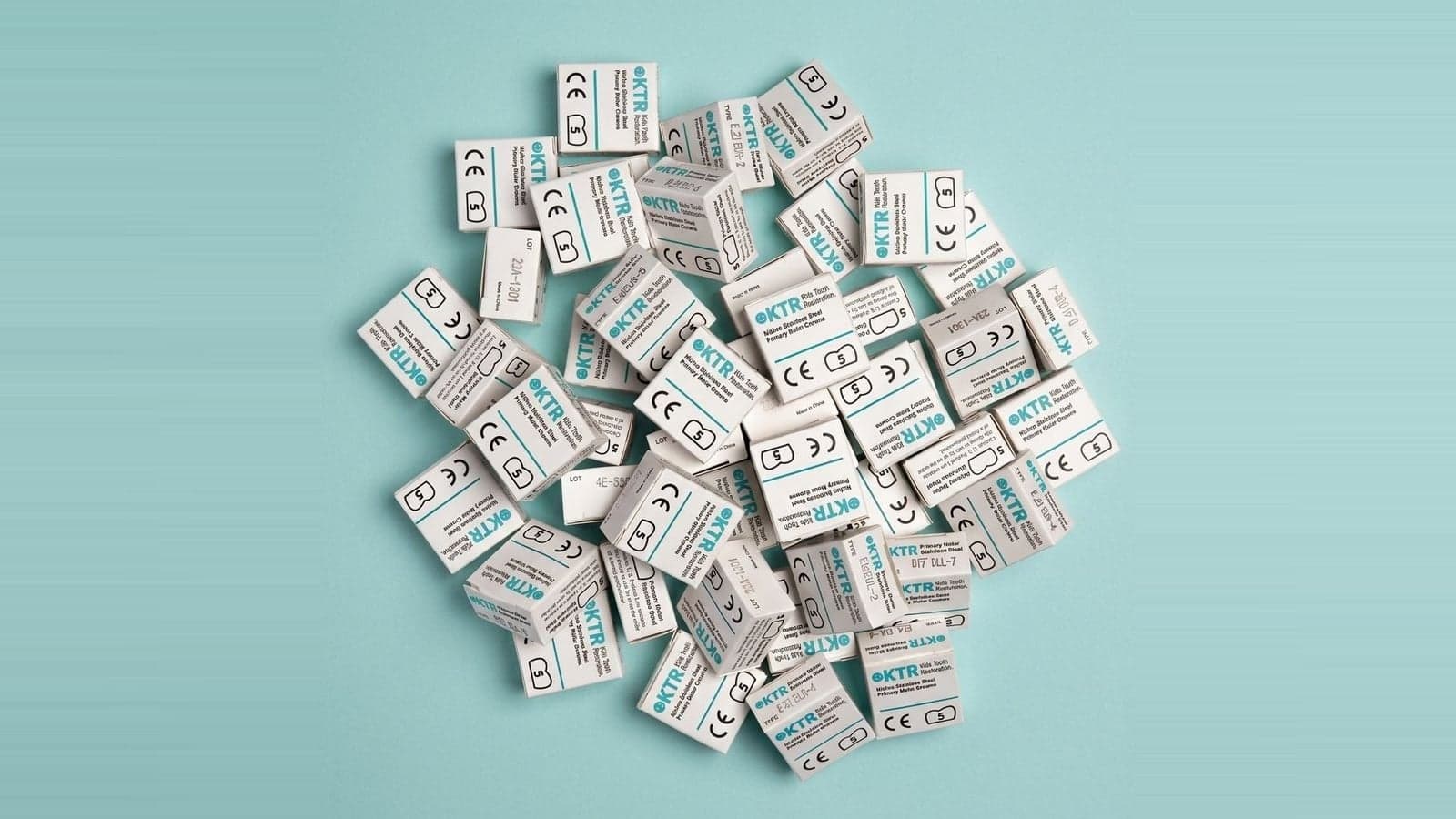 A pile of KTR stainless steel primary molar crown boxes, the crowns reported with CDT code D2930 on primary teeth